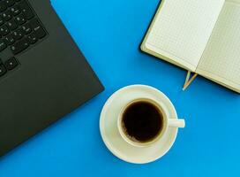 Desktop. Laptop, notepad, coffee cup. photo