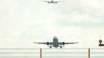 frente vista, el avión toma apagado gastos generales y ganancias altitud. dos aviones en el cielo, cola para aterrizaje y partida. pista y tráfico a dusseldorf aeropuerto video