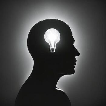 Silhouette of human head with glowing lightbulb on gray background. photo