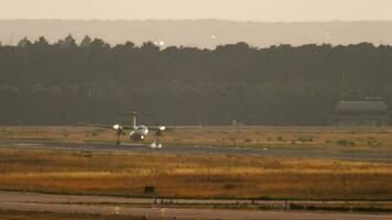 turboélice luz passageiro aeronave pousar, grandes tomada. irreconhecível avião chegado às pôr do sol em uma verão tarde, toque e freio video