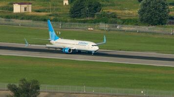 SOCHI, RUSSIA JULY 30, 2022 - Boeing 737 of Pobeda Airlines arriving, braking at Sochi airport, long shot. Tourism and travel concept video