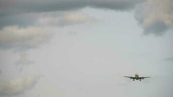 Jet passenger airplane approaching to land, front view. Cloudy sky, the airliner is flying video