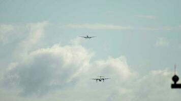 Passenger turboprop plane approaching airport for landing, front view. Line of planes in the sky. Tourism and travel concept video