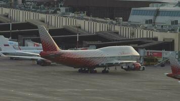 sochi, Rússia Julho 28, 2022 - trator puxar boeing 747 do rossiya em a pista às sochi aeroporto às pôr do sol. jumbo jato em a aeródromo. turismo e viagem conceito video