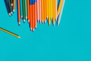 Multicolour pencils isolated on blue background. Close up several colors. photo