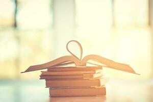 Pile of old books on the table with sunlight and copy space, Stack and one open book, Education learning concept. photo