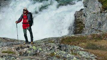 Lycklig caucasian vandrare njuter vattenfall på berg spår video