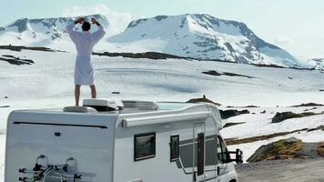 divertente turista godendo mozzafiato nevoso norvegese paesaggio fron il suo camper furgone tetto video