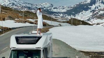 turista extensamente disfrutando escénico paisaje en pie en su camper camioneta mientras umbral en un bata de baño video