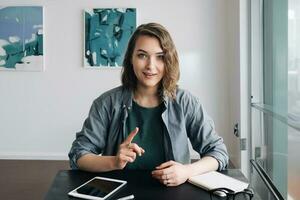 Confident Young Woman Engaging in a Video Conference, Communicating through Web Camera from Office or Home. Life Coaching and Online Business Meeting Concept. Modern Technology and Communication photo