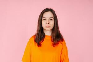 Pretty in Pink. Charming Young Woman in Stylish Orange T-Shirt on Isolated Pink Background. Fashionable and Vibrant Concept photo