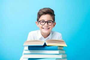 retrato de un contento niño pequeño chico con lentes sentado en un apilar de libros y leyendo un libros, ligero azul antecedentes. ai generado foto