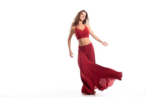 Beautiful young woman in red enjoying her dancing isolated on white background .