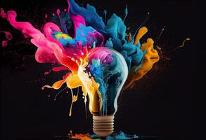 Creative light bulb explodes with splashes of multi-colored paint on a dark background. photo