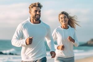 Cheerful European lady and man enjoying active lifestyle and training on ocean beach, having break and posing . photo