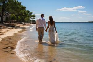 Beach wedding bride and groom walking away down the beach by the water hi definition. photo