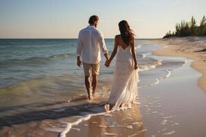 Beach wedding bride and groom walking away down the beach by the water hi definition. photo