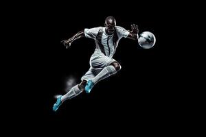 soccer player in mid air kicking ball on a black background . photo