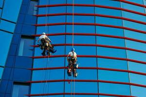 trabajadores limpieza ventanas en negocio centrar en rascacielos foto