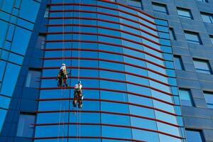 Workers cleaning windows in business center in scyscraper photo