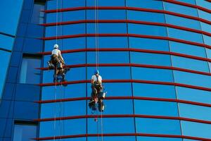 trabajadores limpieza ventanas en negocio centrar en rascacielos foto