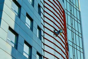 Workers cleaning windows in business center in scyscraper photo