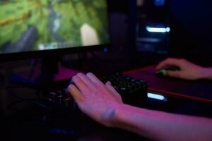 Gamer play computer game, use rgb neon colored keyboard photo