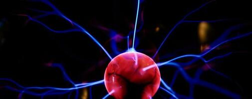 Plasma ball with energy rays on dark background photo