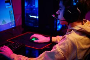 Boy plays computer game at home, gaming addiction photo