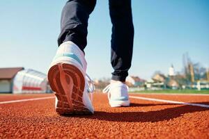 Runner feet running at sport stadium track photo