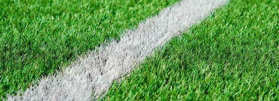 Green grass on sport field with white line photo