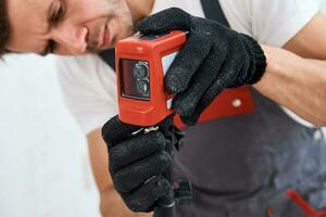 Renovation concept. Male worker using laser level photo