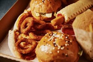 Unhealthy and junk food. Different types of fast food on the table, closeup photo