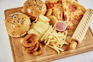 Unhealthy and junk food. Different types of fast food on the table, closeup photo