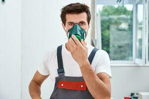 Portrait of home repair worker. Renovation handyman with puts on respirator photo