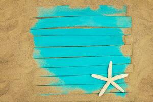 White starfish on blue wooden boards in the sand on the beach. Nautical summer postcard. Travel, vacation. Copy space photo