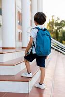 Student boy with backpack on way to school. Concept of back to school. photo