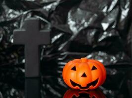 Jack the pumpkin and a scary grave cross on a creepy, dark night. A Halloween scene with a copy of the space. photo