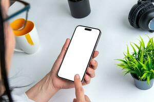 Woman touch smart phone with isolated display for mockup fort app or od web page presentation. Office desk in background photo