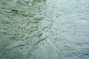 The texture of the water of the river. Natural water background with ripples and waves. photo