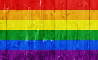 Flag of the LGBT community on the background of the wooden texture of the boards. Rainbow gay culture symbol. Concept collage. photo