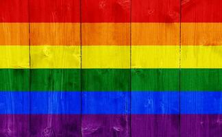 Flag of the LGBT community on the background of the wooden texture of the boards. Rainbow gay culture symbol. Concept collage. photo