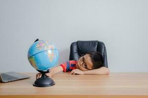 Asian boy looking at world map photo