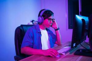 Asian man playing games at home at night photo