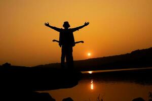 Silhouette of a person on a rock near the reservoir photo