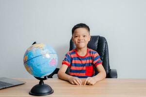 Asian boy looking at world map photo