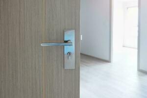 Closeup doorknob of wooden door between open or close the door photo