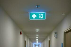 Fire Emergency exit sign on the wall background inside building. Safety concept photo