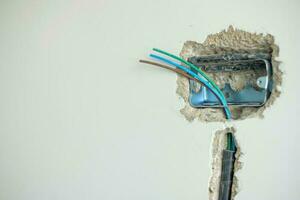 Electrical Wiring under plaster, hidden installation cables for socket to a concrete. Renovation, Repair and development of home and apartment concepts photo