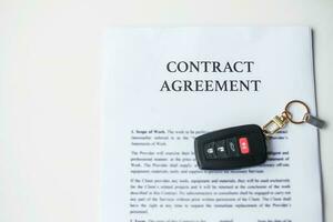 contract document with car and remote key. buy and sale, insurance, rental and contract agreement concepts photo